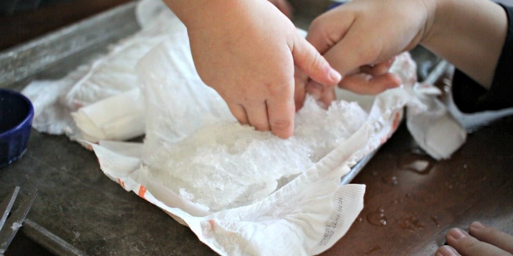 Close-up of Super Absorbent Diaper Polymer beads in a clear container, showcasing their high absorbency and non-toxic nature. The image highlights the small, translucent beads designed for optimal performance and safety in diapering solutions."